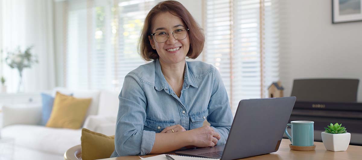 Frau mit Laptop, Lächelnd, in die Kamera blickend, Arbeitslos, Arbeitsuchend, Was tun, Beratung, Hilfe, Unterstützung, GFN